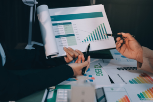 Deux professionnels dans un bureau analysent un document avec les chiffres résultats croissance de leur entreprise.