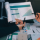 Deux professionnels dans un bureau analysent un document avec les chiffres résultats croissance de leur entreprise.