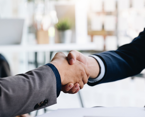 Deux hommes en situation professionnelle se serrent cordialement la main